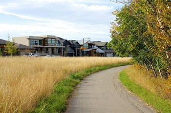 trail connecting Larch Park residential development to the adjacent Larch Sanctuary, bordered by a naturalized area